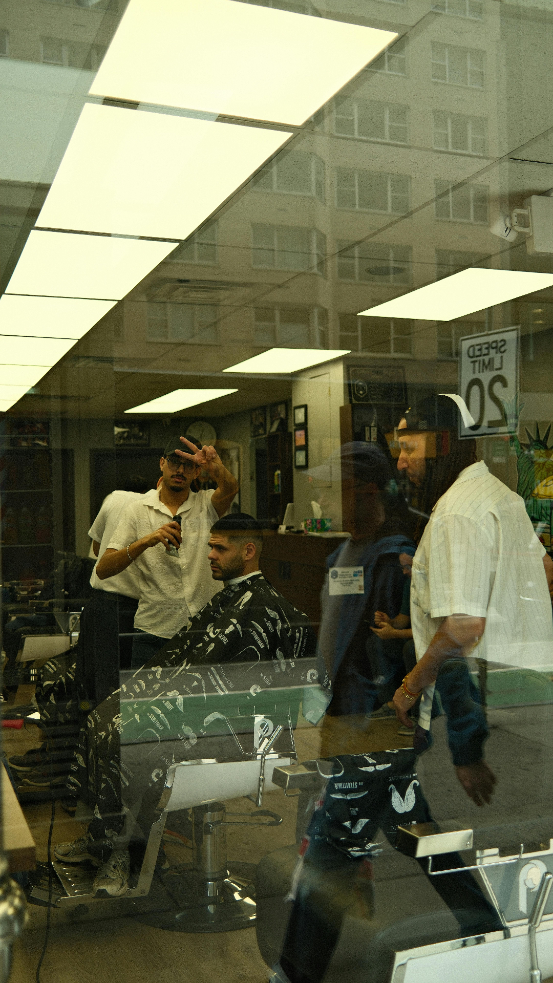 Barber at work – shop window reflection